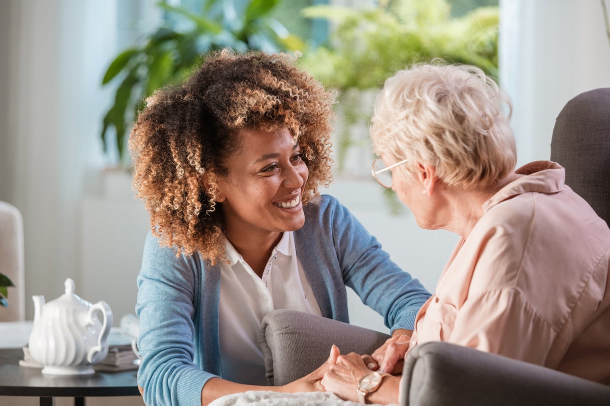 Home caregiver taking care of elderly woman